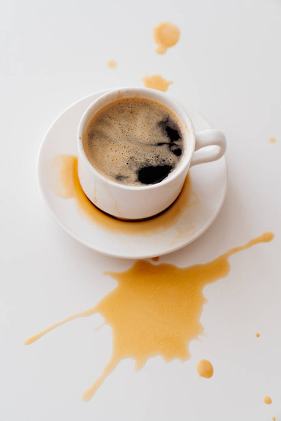 Pohled nahoru. z šálku šplouchání kávy na bílém stole. tradiční ranní snídaně. živost v časných ranních stoupáních. cappuccino - Fotografie, Obrázek