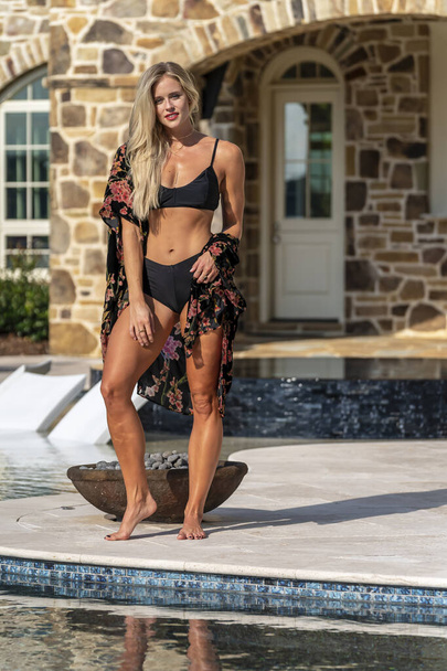 A gorgeous blonde bikini model enjoys a summers day by the pool - Zdjęcie, obraz