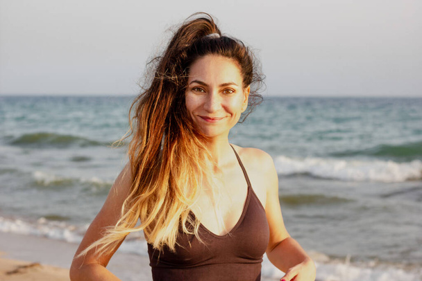 Attractive fit caucasian woman doing fitness on a beach - Fotó, kép