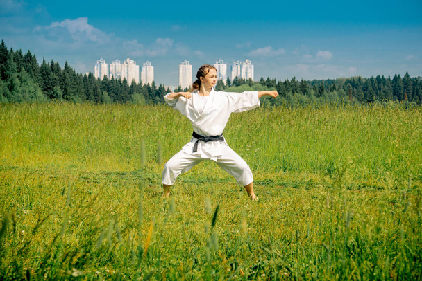 tiener meisje oefenen karate kata buiten - Foto, afbeelding