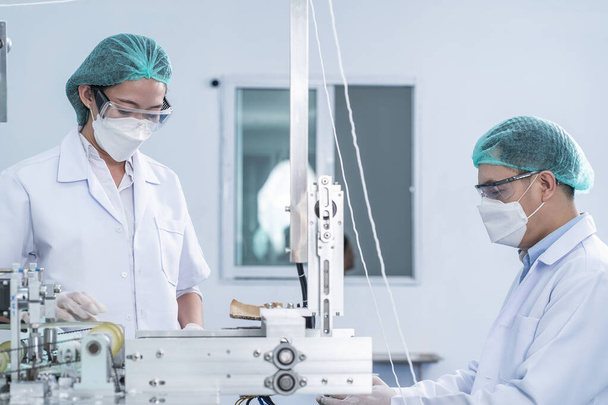 Supervisor, technical supervisor, engine, wears antimicrobial suit, inspects, repairs, maintains machinery, produces quality slide products and gets the job done on time in a medical device factory - Fotografie, Obrázek