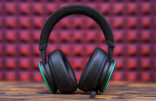 Επαγγελματικά σύγχρονα ακουστικά με μικρόφωνο για gamers σε ροζ φόντο - Φωτογραφία, εικόνα