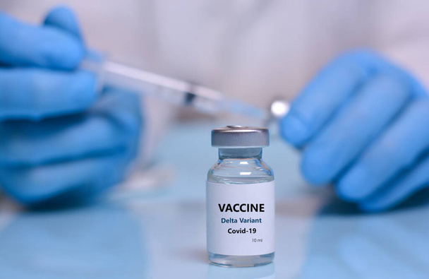 Lääkäri lääketieteellisissä käsineissä on pullo, jossa on koronavirus Covid19 Delta variantti kanta rokote.Käsite lääketieteen, terveydenhuollon ja tieteen. - Valokuva, kuva
