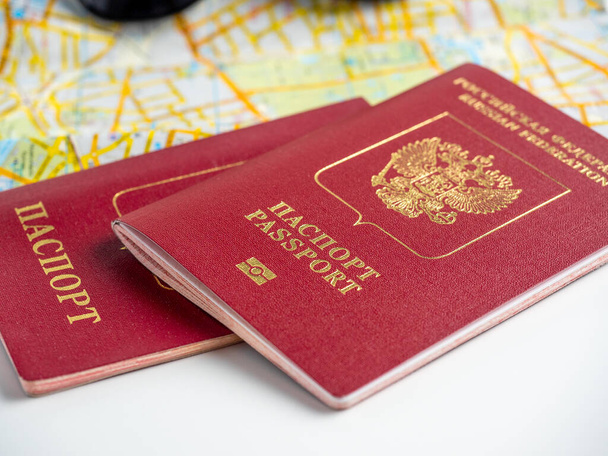 крупным планом двух российских паспортов, лежащих на карте города. Концепция путешествий и миграции - Фото, изображение