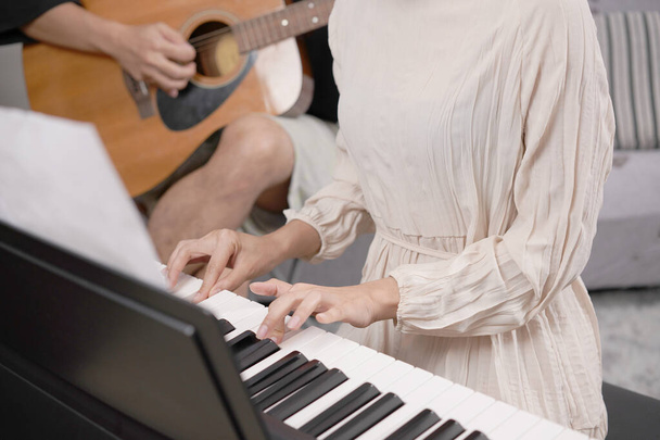 Дорослі жінки грають на електропіаніно з приміткою. Піаніст - новачок практикує і вчиться грати в пісні.. - Фото, зображення