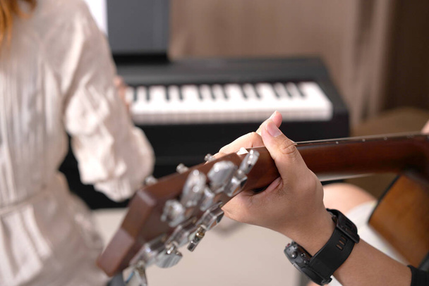 Erwachsene Frauen und Männer spielen elektronisches Klavier mit Notenblatt. Neuer Pianist übt und lernt, wie man singt. - Foto, Bild