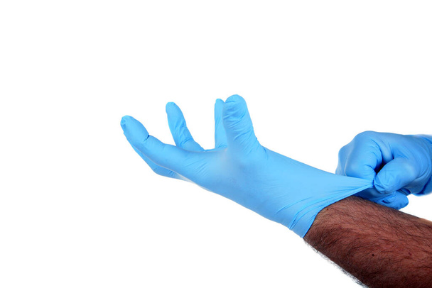 Medizinische Handschuhe.Zwei blaue OP-Handschuhe. isoliert auf weiß. Gummihandschuh. Die menschliche Hand trägt einen Latexhandschuh. Arzt oder Krankenschwester ziehen Schutzhandschuhe an. Medizinische Nitrilhandschuhe. Schneideweg. Raum für Text.  - Foto, Bild