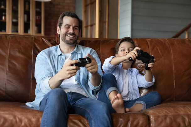 Happy excited preschooler kid and dad playing video game - Foto, Imagen