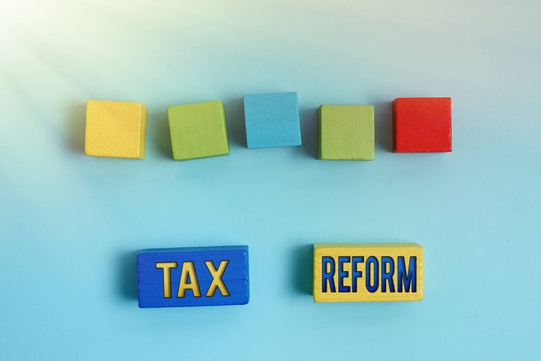 Vergi Reformunu sunan metin başlığı. Hükümetin, işletme sahipleri ile birlikte vergi tahsilatı hakkındaki politikası için, Yüzeyde Çok Renkli Dörtgen Kutular Cilalanıyor - Fotoğraf, Görsel