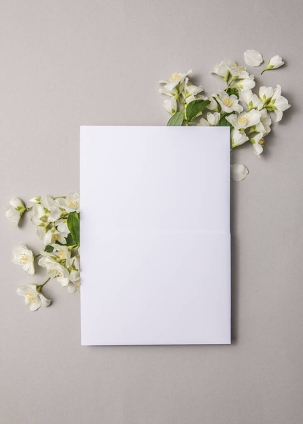 Romantická blahopřání pohlednice s přiloženým přírodním čerstvým jasmínem květiny na šedém pozadí, kopírovat prostor - Fotografie, Obrázek