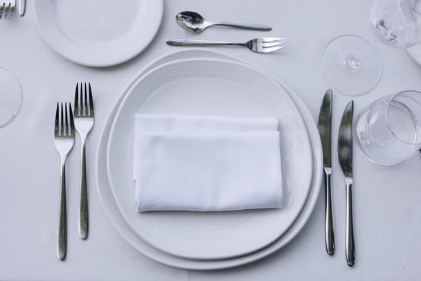 tableware Glasses, flower fork, knife served for dinner in restaurant with cozy interior - Foto, Imagem