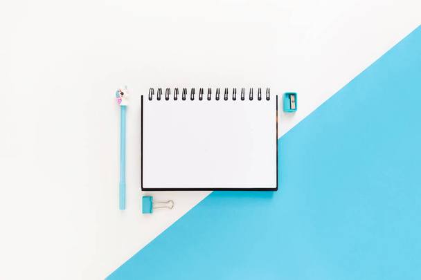 Top view of modern white blue office desktop with school supplies and stationery on table around empty space for text. Back to school concept flat lay with mockup - Photo, image