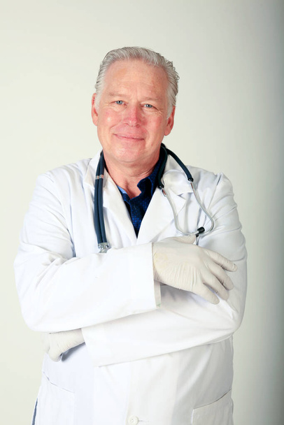 Doctor. Handsome Male Doctor. Portrait of a friendly handsome doctor in his lab coat. smiling mature doctor. Male doctor standing in the hospital office. Medical healthcare and doctor service. Handsome middle-aged Caucasian male professional doctor. - Фото, зображення