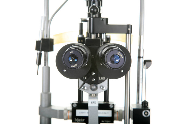  Lampa szczelinowa. Okulista Lampa szczelinowa. izolowany na biało. miejsce na SMS-a. Lampy ślizgowe są używane przez okulistę i okulistę, a specjaliści ds. pielęgnacji oczu, aby spojrzeć w oczy za pomocą mikroskopu. mikroskop do lamp szczelinowych.  - Zdjęcie, obraz