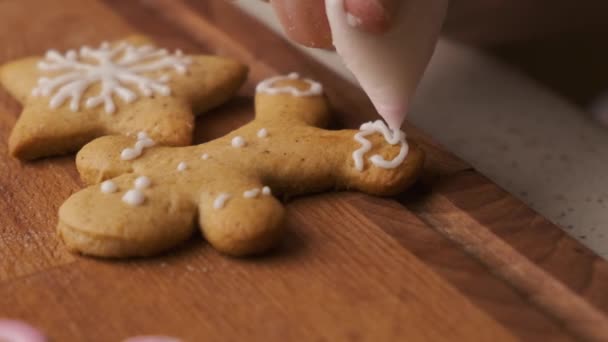 アイシングとジンジャーブレッドの男性の形でクリスマスクッキーの装飾プロセス.  - 映像、動画
