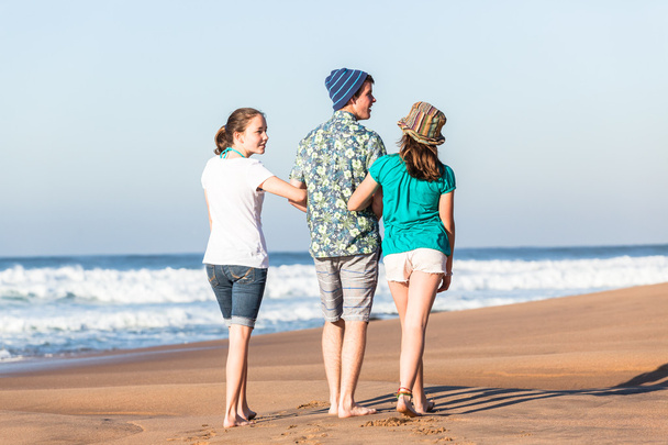 Teini-ikäinen poika tytöt hengailua rannalla aallot
 - Valokuva, kuva