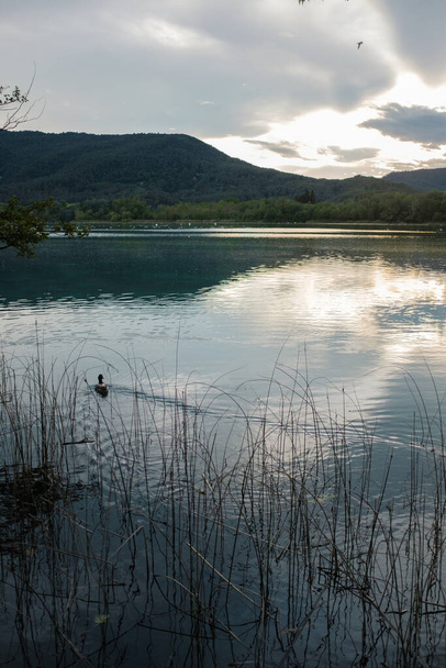 Cloudy sunset on quiet water lake in Banyoles, Catalonia - Photo, Image