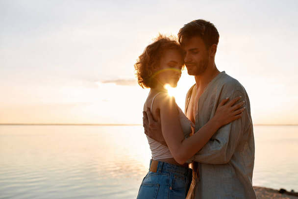 Sensual young caucasian couple embracing at sunset - Zdjęcie, obraz