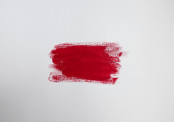Crimson red paint patch on plain white background with copy space - Foto, imagen