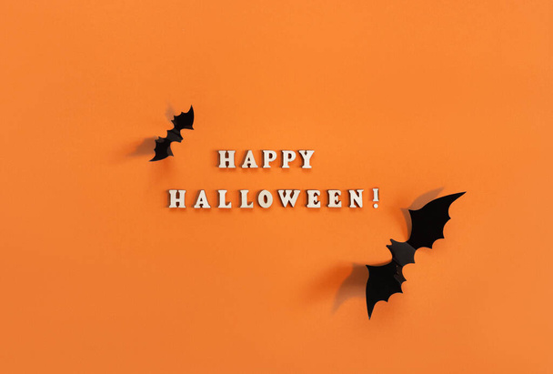 Halloween card with black bats on orange background. Banner for congratulations or invitation. - Foto, afbeelding