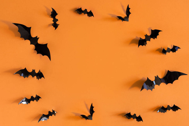 Halloween card with black bats on orange background. Banner for congratulations or invitation. - Foto, imagen