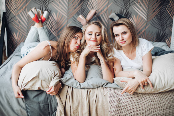 Meninas alegres se deita em sua cama, goza de sua vida e sorri - Foto, Imagem