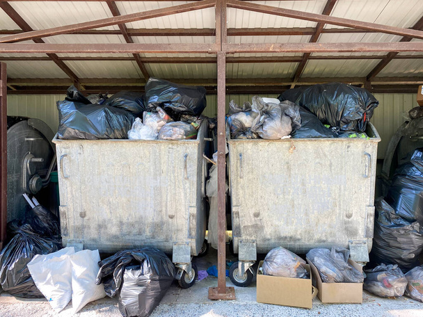 Мешки с мусором в мусорном контейнере. Много мусора было выброшено в контейнеры - Фото, изображение
