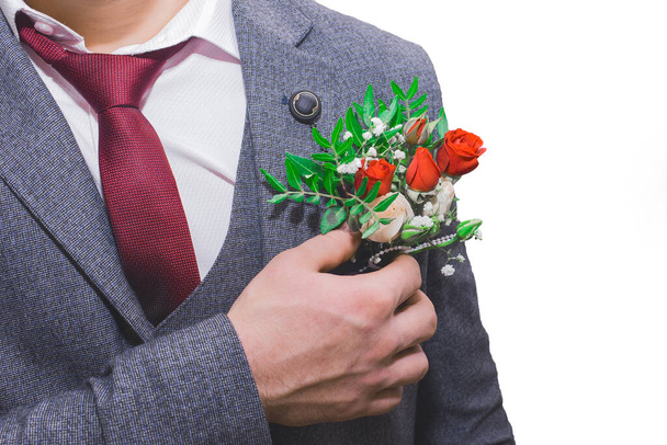 Groom's hand at wedding corrects boutonniere close-up. - Foto, afbeelding