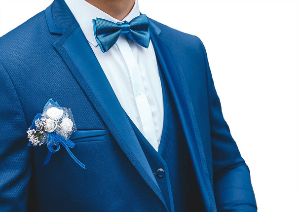Muž v bílé košili, modrý oblek s motýlem a boutonniere na bílém pozadí, izolovaný, detailní záběr. - Fotografie, Obrázek