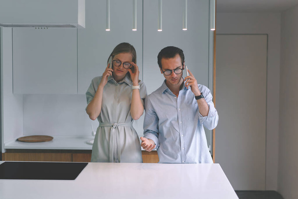 Millennial family couple working from home and talking by phones - Foto, imagen