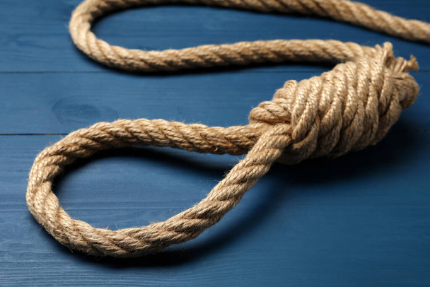 Rope noose with knot on blue wooden table, closeup - Photo, Image