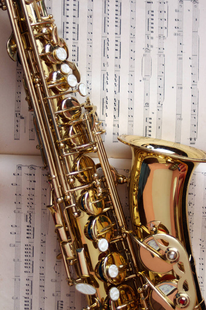 primer plano del saxofón de oro en partituras  - Foto, Imagen