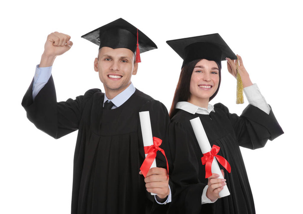 Happy students in academic dresses with diplomas on white background - Foto, imagen