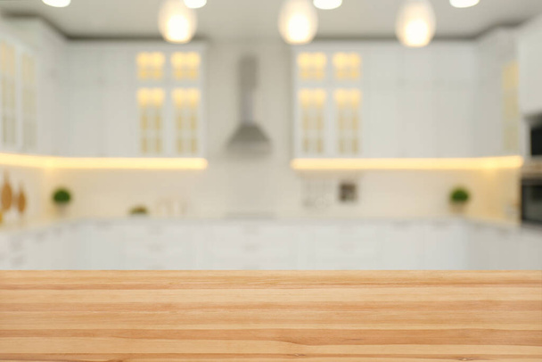Empty wooden table and blurred view of stylish kitchen interior. Mockup for design - Photo, Image