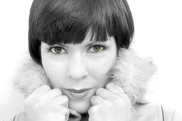 Das Gesicht einer jungen hübschen Frau mit Pelzkragen in schwarz-weiß - Foto, Bild