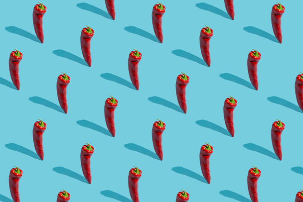 Pattern made of red standing pepper on pastel blue background - Φωτογραφία, εικόνα
