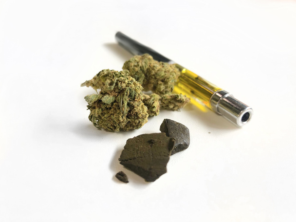 Different forms of marijuana, like golden  resin in a vape pen, hashish and weed, or grass - Foto, imagen