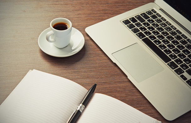 escritorio con una taza de café ordenador portátil, portátil, pluma
 - Foto, Imagen