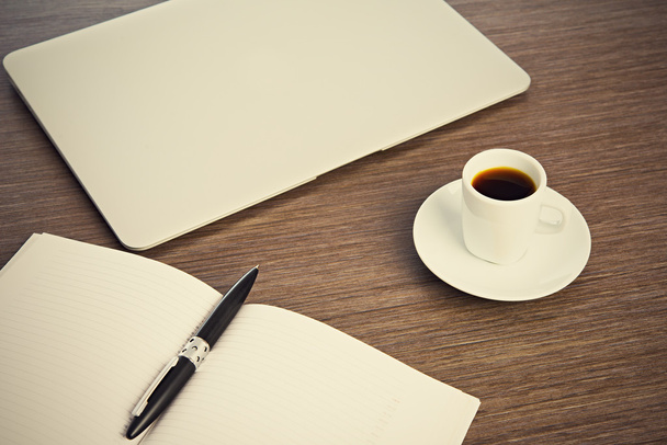 scrivania con una tazza di caffè computer portatile, notebook, penna
 - Foto, immagini