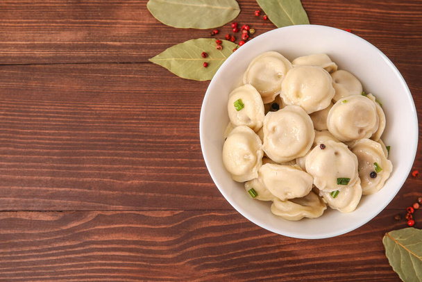 Bowl with tasty dumplings on wooden background - Photo, Image