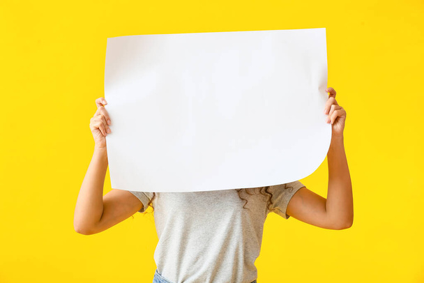 Young woman with blank poster on color background - Фото, изображение