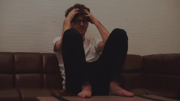 Desperate man sitting with hands on his head on a sofa for stress and depression concept. - Footage, Video