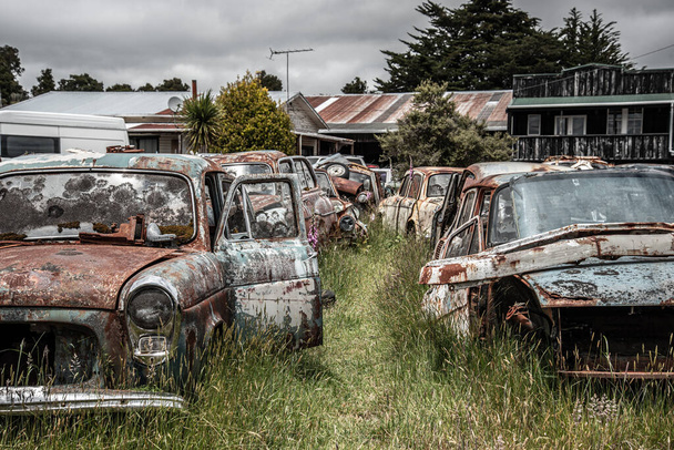 Antike Autos auf einem großen Schrottplatz am Ende des Old Coach Road Trail, Nordinsel Neuseeland - Foto, Bild