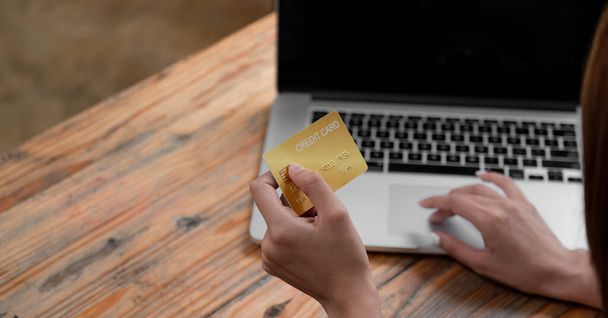 Ruce držící kreditní kartu a používající notebook. Online nakupování v kavárně - Fotografie, Obrázek