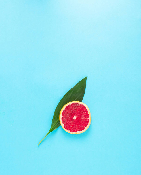 Listy a grapefruity na modrém pozadí jako minimální koncept - Fotografie, Obrázek