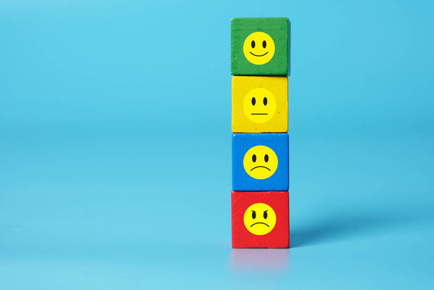 Il colore vario di blocco di legno consiste di emoticon felice, neutrale, triste e arrabbiato. Concetto di espressione e sentimento - Foto, immagini