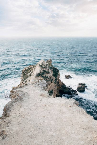 Stone ridge extending into a stormy sea. - Photo, image