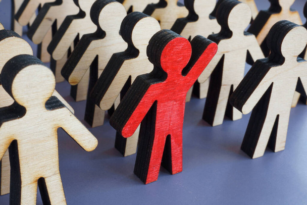 Initiative and activism concept. Unique figurine with a raised hand in a crowd. - 写真・画像