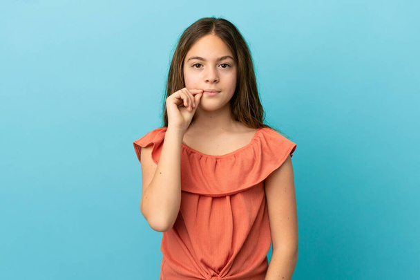 Little caucasian girl isolated on blue background showing a sign of silence gesture - Photo, Image