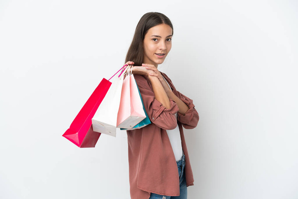 Beyaz arka planda izole edilmiş genç bir Fransız kız elinde alışveriş torbaları tutuyor. - Fotoğraf, Görsel